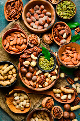 peeled and shelled nuts in wooden bowls. Top view. On a dark background.