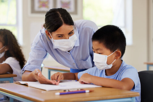 Covid, Students And Education Teacher Helping Learning Children In School Classroom To Answer Math Question. Woman With Face Mask Teaching Asian Boy In Lesson With Diverse Class Of Kids Or Classmates