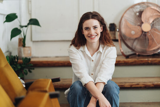 Smiling Young Woman in Casual Jeans, Contentment Indoors.