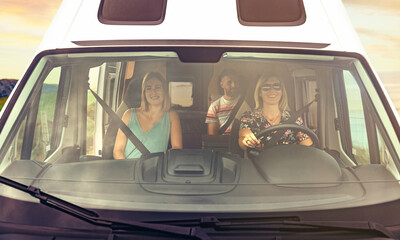 Front view through windshield of friends group traveling in camper van