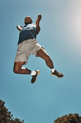 Sports, blue sky and basketball man jump for game, competition or slam dunk training, practice or...