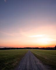 Fototapeta na wymiar Sunset on a beautiful landscape scenery, lonely road