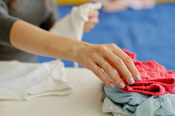 Fototapeta premium Closeup image of mother ironing clothes for her daughter