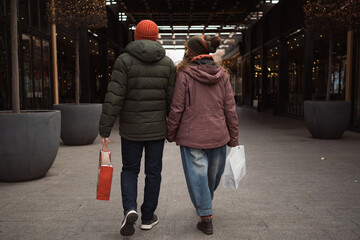 Real people - couple in love shopping together at winter holidays