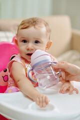 Little girl drinking water from plastic bottle