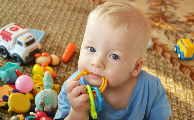 Fototapeta na wymiar Baby gnaws at a toy, grows teeth