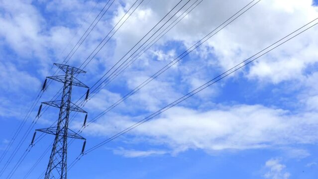 power lines. blue sky with clouds. cloud timelipse bright blue sky background. white cloud hyperlipse. summer weather in the countryside. no people.
