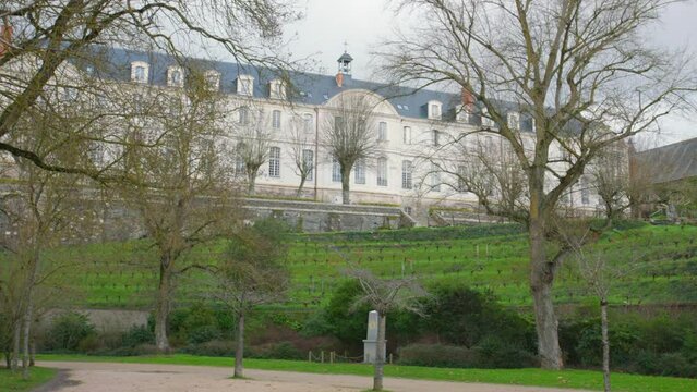A View Of Abbaye Saint-Nicolas Architecture With Vineyards In Angers, France. Wide Shot