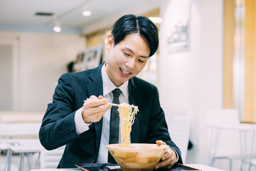 ラーメンを食べる日本人男性ビジネスマン