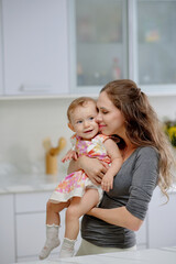 Joyful mother hugging little daughter expessing her love and care