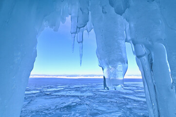 Ice Cave with Crystal Blue Icicles During Sunrise at Lake Baikal