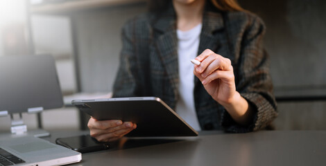 business documents on office desk with laptop and smart phone and graph business diagram and man working in morning light.
