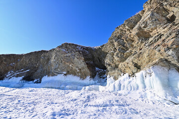 Fototapeta na wymiar Winter Landscape of Rock Cliffs with Ice and Frozen Lake Baikal