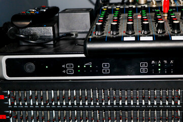 Close up of professional audio mixing console with sliders and buttons.