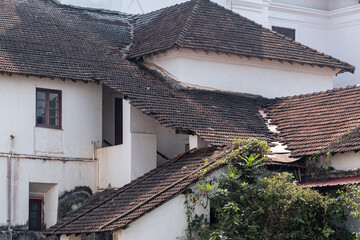 Vintage architecture of sloping tiled roofs of the ancient Portuguese era St. Francis of Assisi church in Old Goa.