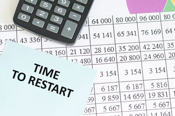 TIME TO RESTART text written on a notebook on background with chart and keyboard , business concept