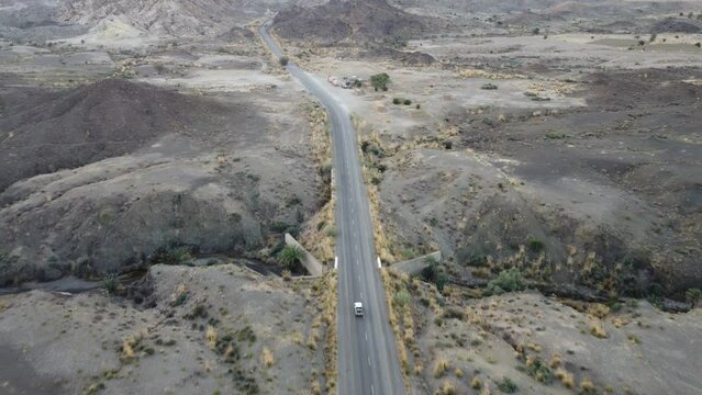 Aerial Overhead View Of Vehicle Driving Along RCD Road In Balochistan. Dolly Forward 