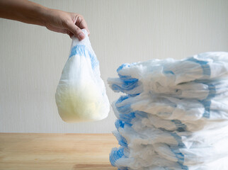 New and hand holding dirty kids diaper full of children's pee