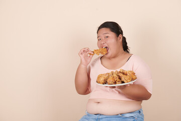 chubby asian woman express happiness when eating fried chicken, food addiction, diet breakdown,...