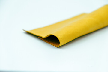 Yellow leather is folded on a white background