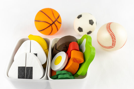 玩具のボールとお弁当。スポーツで弁当を食べるイメージ