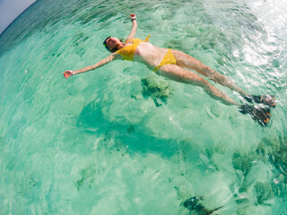 woman snorkeling in clear tropical sea
