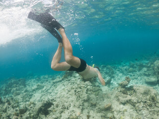 man snorkeling in crystal clear tropical sea