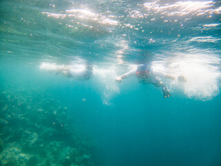Fototapeta na wymiar couple snorkeling in clear tropical sea