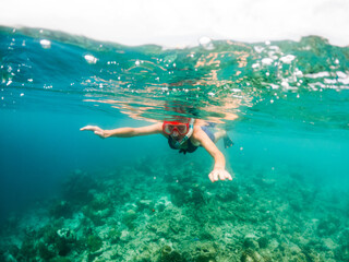 Obraz na płótnie Canvas woman snorkeling in clear tropical sea