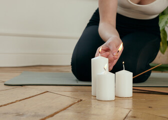 a woman lights candles for yoga classes