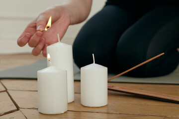 a woman lights candles for yoga classes