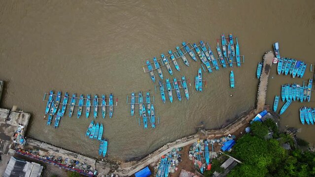 Overhead drone shot of Rows of fishing boats parked at the fish auction harbor - Baron Beach, Yogyakarta, Indonesia