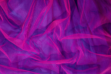 Elegant wallpaper made of vivid pink tulle fabric on purple background. Aesthetic fashion and love...