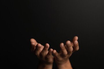 Fototapeta premium Man hands pray on bible. Praying hands with faith in religion and belief in God on dark background.