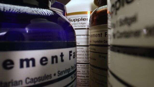 Dietary Supplements Containers. White Plastic Cans for Tablets. Fish oil, Omega 3 or D-3 Pills for a Healthy Lifestyle. Supplement Facts. The Camera Moves Through Containers of Dietary Supplements