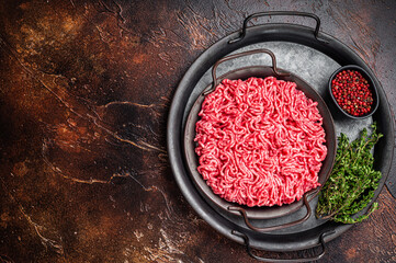 Raw Mince, minced Ground beef meat in a kitchen tray. Dark background. Top view. Copy space