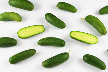 Cut and whole seedless mini avocados isolated on white. A group of mini avocado or cocktail avocado stacked to pyramid on white background. Green vegan functional food for healthy lifestyle, superfood