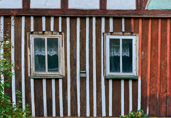Wooden wall of the old house with the window and lace curtains
