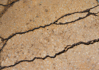 Obraz premium Brown concrete craked wall. Stone background with fractures.