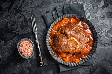 Braised meat on the bone Osso Buco in tomato sauce, veal italian meat Ossobuco. Black background....