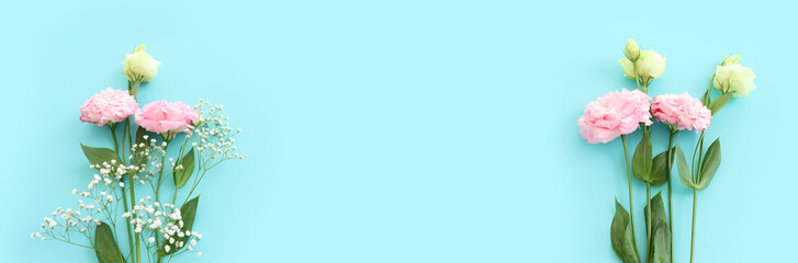 Top view image of delicate lisianthus flowers over pastel blue background