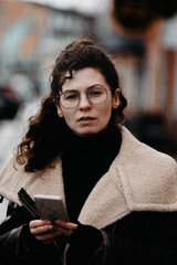 curly woman with glasses in the city portrait