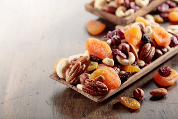 Mix of nuts and dried fruits on an old wooden table.