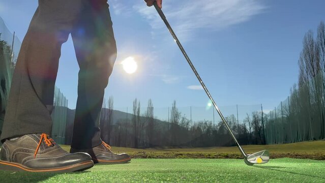Golfer Training Golf Swing on Driving Range with Sunlight in Switzerland.