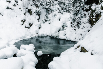A snowy day in a mountain village by the river