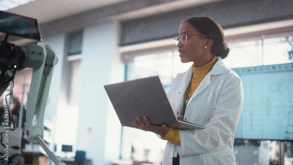 Poster Portrait of Young Black Female Specialist in a Lab Coat Smiling and Using Laptop Computer. Professional and Successful Woman Working as an Engineer, Developing High Technology Projects