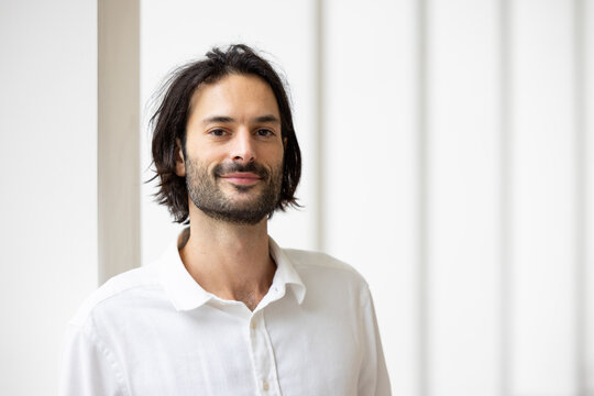 portrait d'un jeune homme de 30 ans souriant qui regarde la cam&eacute;ra. Il est debout dans son bureau. Homme d'affaires ou employ&eacute; de bureau.