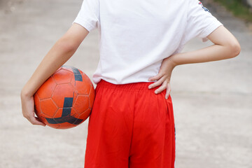 Back view of boy holds ball outdoor alone. Concept, sport, workout, exercise for health. Free...