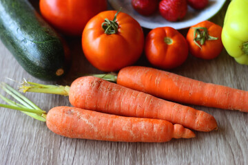 Berries in vintage porcelain dishes, other healthy fruit and vegetable on wooden table. Selective focus.