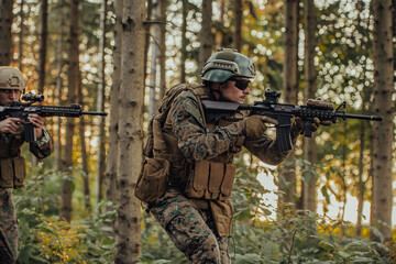 Fototapeta premium A group of modern warfare soldiers is fighting a war in dangerous remote forest areas. A group of soldiers is fighting on the enemy line with modern weapons. The concept of warfare and military